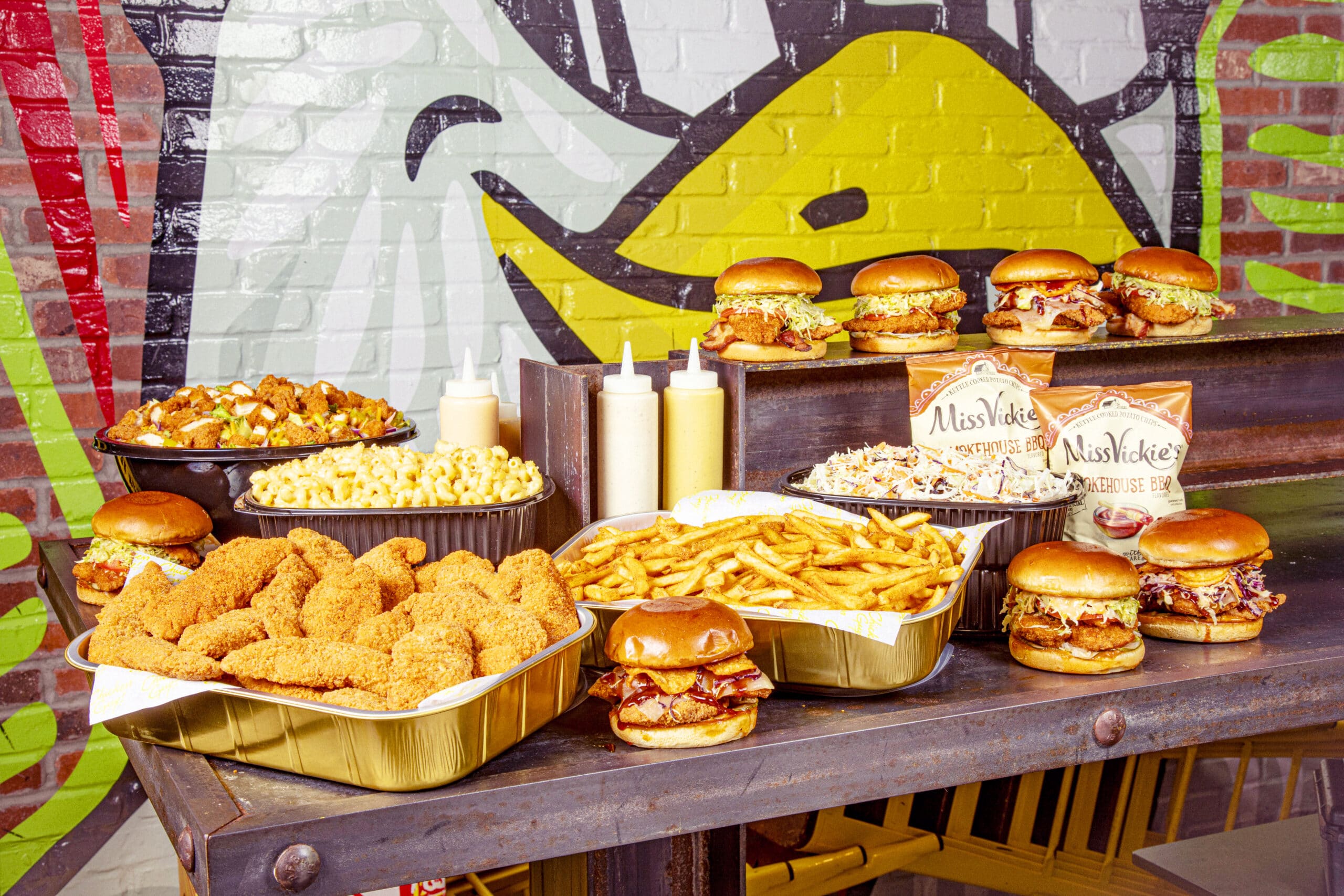 Catering spread featuring tenders, sandwiches and many sides.